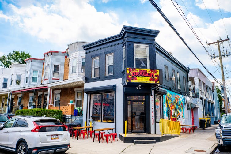 Exterior shot of a restaurant with outdoor seating in ground floor of rowhome