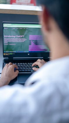 Man typing on laptop, screen open to ChatGPT website